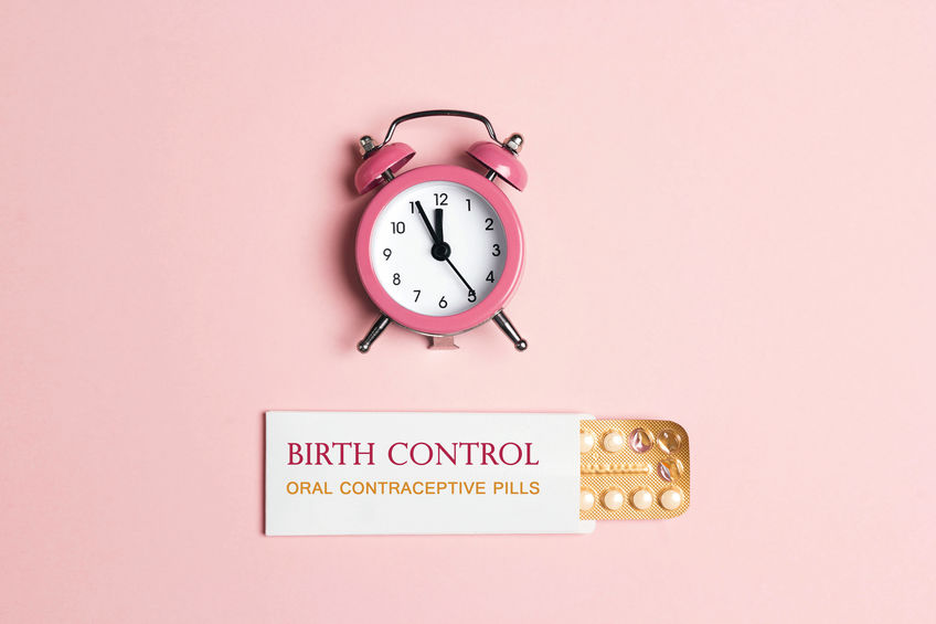 Alarm clock next to birth control pill pack, reminding you to take your pill on time.