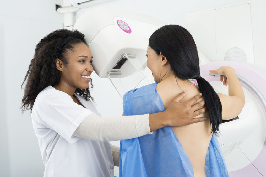 doctor performing a mammogram on patient 