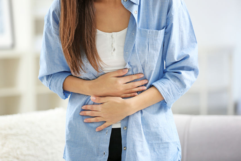 woman holding abdomen in pain 