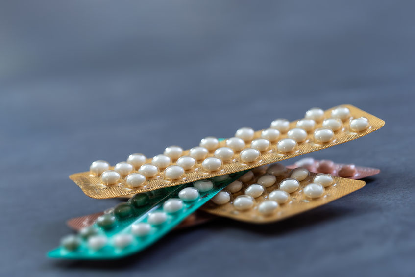 packages of birth control pills isolated on grey slate