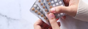 woman hand holding birth control pills close up