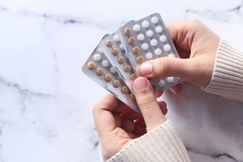 woman hand holding birth control pills close up