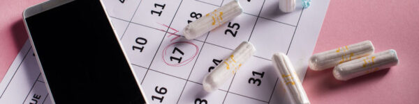 Clean white tampons, calendar and mobile phone on pink background