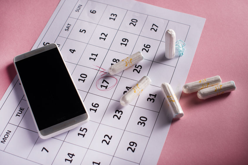 Clean white tampons, calendar and mobile phone on pink background
